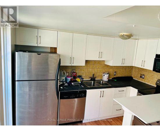 A kitchen with white cabinets and a stainless steel refrigerator.