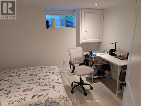 A bedroom with a bed, desk, and chair.