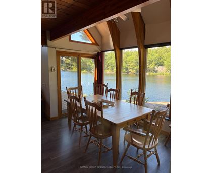 A dining room with a table and chairs overlooking a body of water.