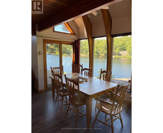 A dining room with a table and chairs overlooking a body of water.