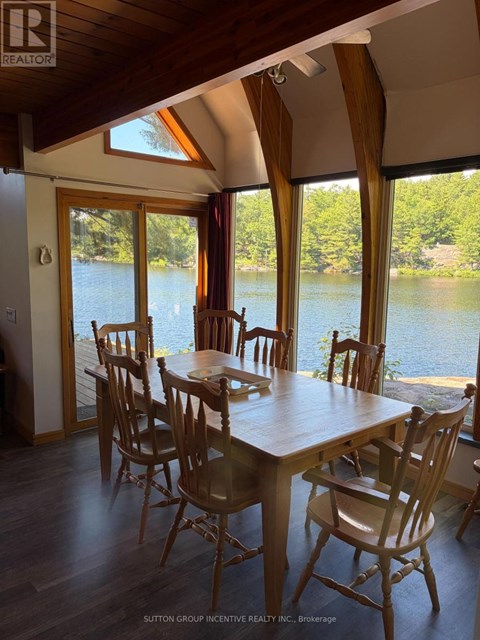 A dining room with a table and chairs overlooking a body of water.