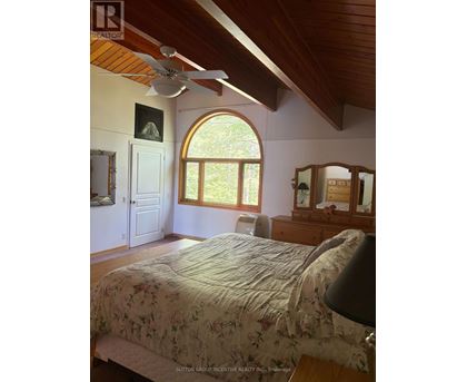 A bedroom with a large bed and a ceiling fan.