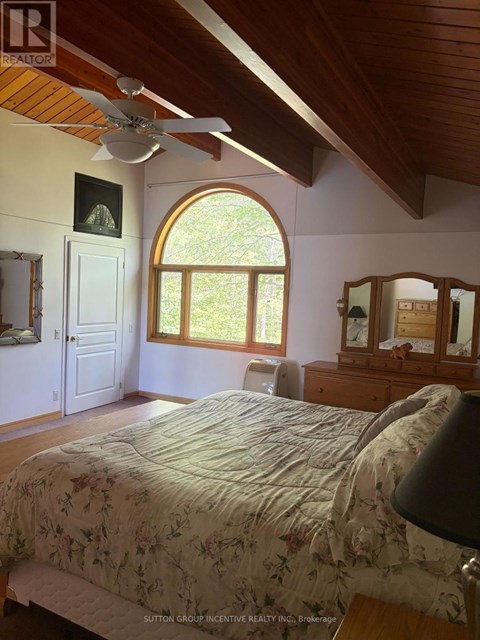 A bedroom with a large bed and a ceiling fan.