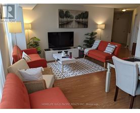 A living room with a television, red couches, and a coffee table.
