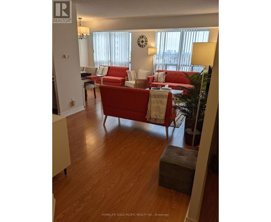 A living room with a red couch and a wooden floor.