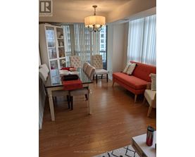 A living room with a red couch and a wooden floor.