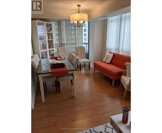 A living room with a red couch and a wooden floor.