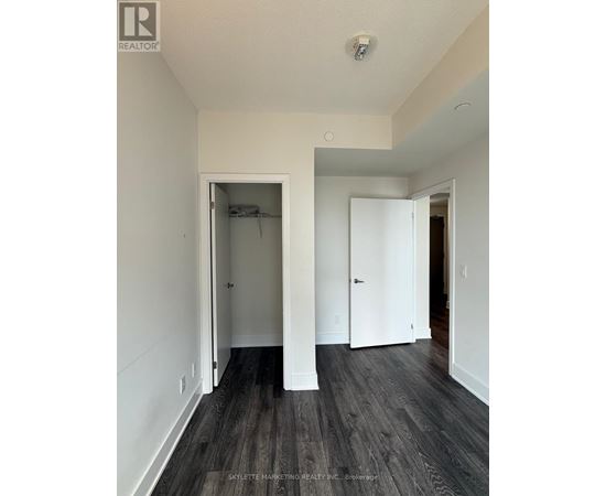 A room with a white door and a black floor.