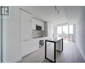 A modern kitchen with white cabinets and a black table.
