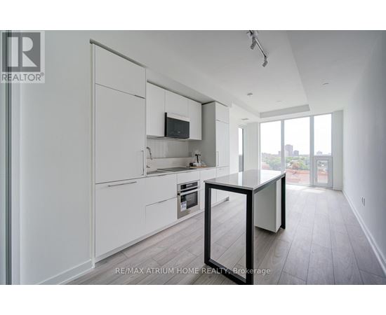 A modern kitchen with white cabinets and a black table.