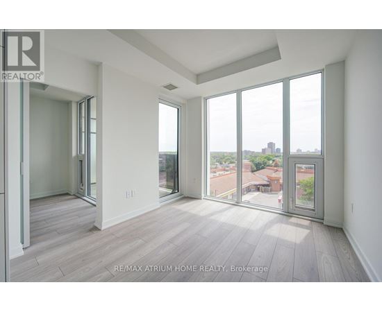 A spacious room with a view of the cityscape through large windows.