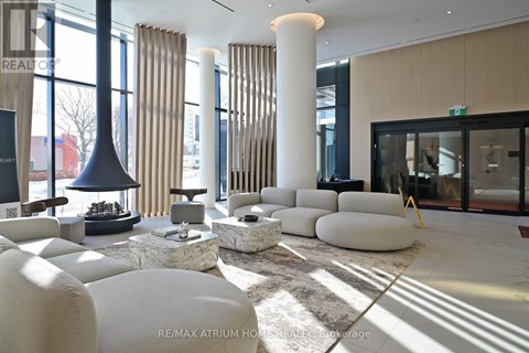 A modern living room with white furniture and a large window.