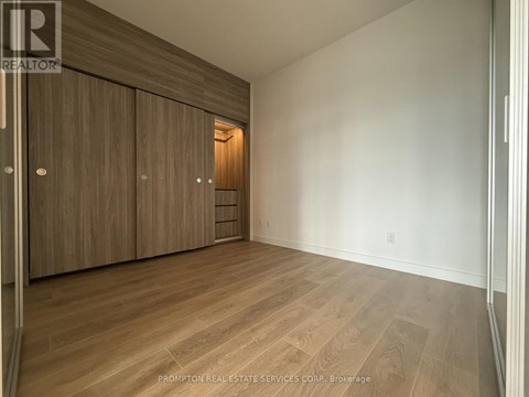 A room with wooden flooring and a wall of cabinets.