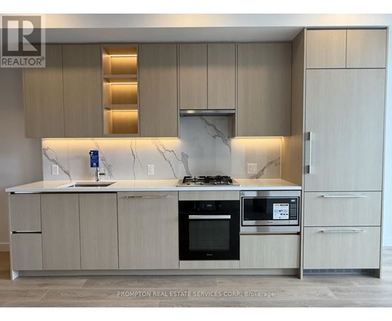 A modern kitchen with a marble countertop and stainless steel appliances.