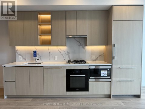 A modern kitchen with a marble countertop and stainless steel appliances.