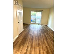 A room with wooden flooring and a sliding glass door.