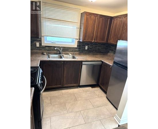 A kitchen with brown cabinets and a black stove top oven.