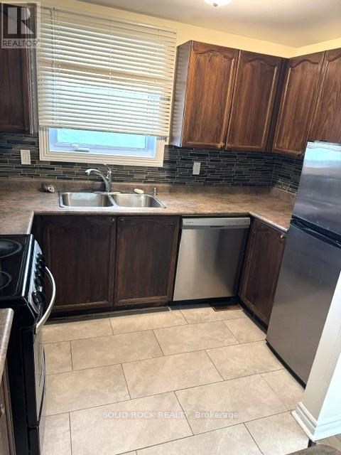 A kitchen with brown cabinets and a black stove top oven.