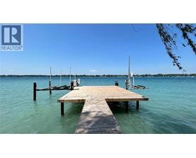 A wooden dock extends into a calm body of water.