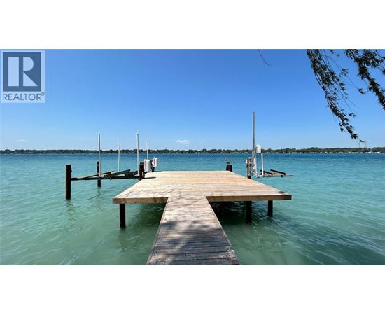 A wooden dock extends into a calm body of water.