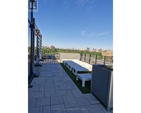 A rooftop patio with benches and a view of the city.