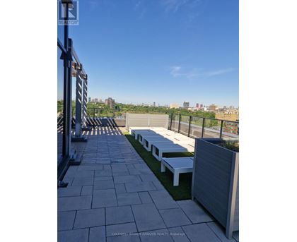 A rooftop patio with benches and a view of the city.