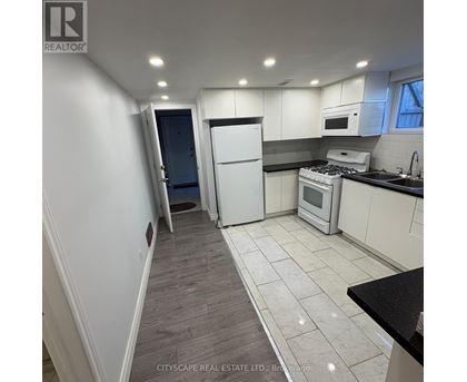 A kitchen with white cabinets and a black countertop.
