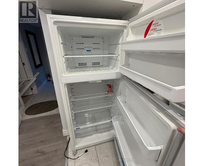 A white refrigerator with the door open and shelves inside.