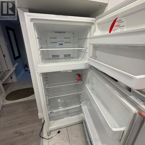 A white refrigerator with the door open and shelves inside.