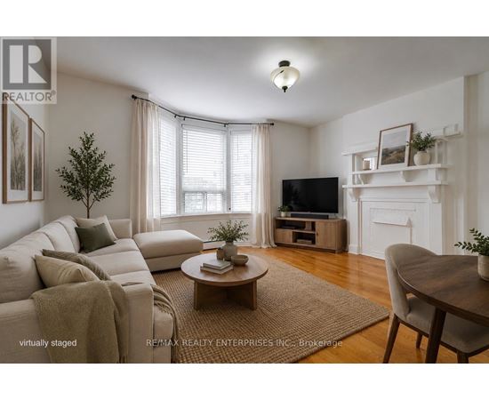 A living room with a couch, a coffee table, a television, and a fireplace.