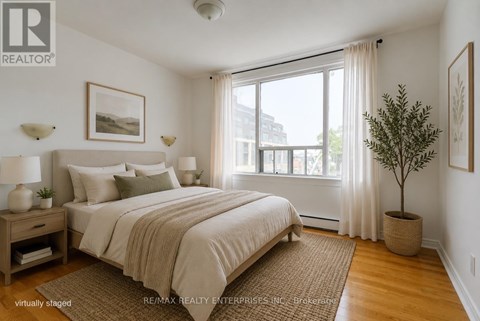 A bedroom with a large bed and a view of the city.