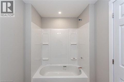 A white bathroom with a bathtub and a toilet.
