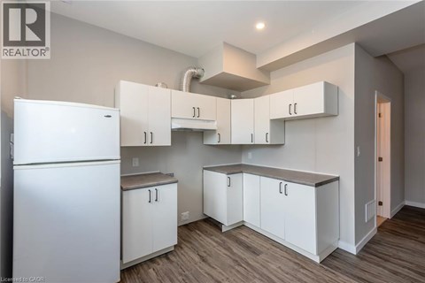 A kitchen with white cabinets and a white refrigerator.