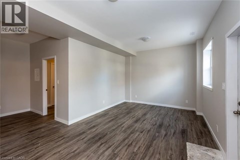 A room with wooden flooring and white walls.