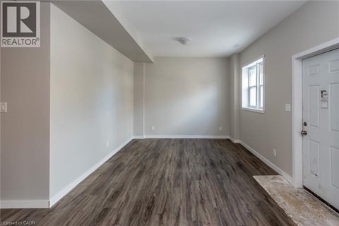 A room with wooden flooring and white walls.