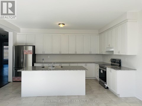 A kitchen with white cabinets and a white island.
