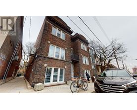A brick house with a bicycle leaning against it.