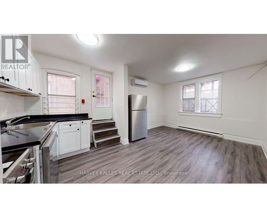 A kitchen with a stove top oven and a refrigerator.