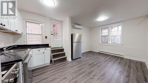 A kitchen with a stove top oven and a refrigerator.