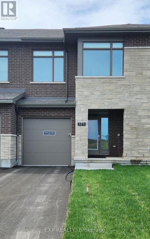 A house with a grey garage door and a black front door.