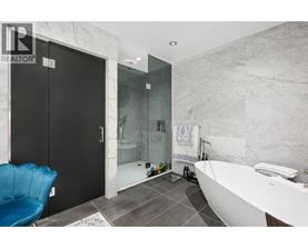 A bathroom with a black door and a blue chair.