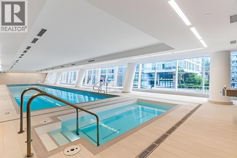 A large indoor swimming pool with a glass barrier.