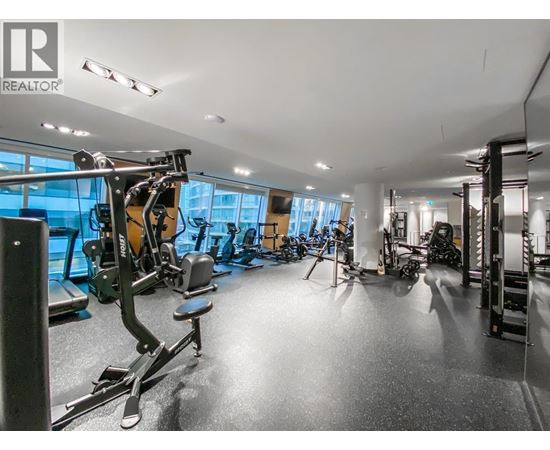 A gym with a variety of equipment including treadmills, weights, and exercise machines.