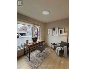 A room with a desk, chair, and pictures on the wall.