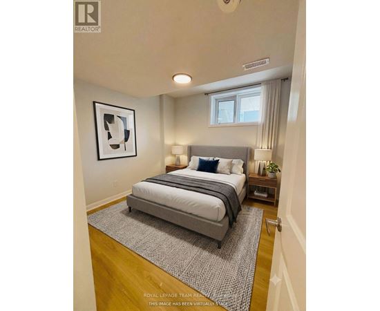 A bedroom with a large bed and a framed picture on the wall.