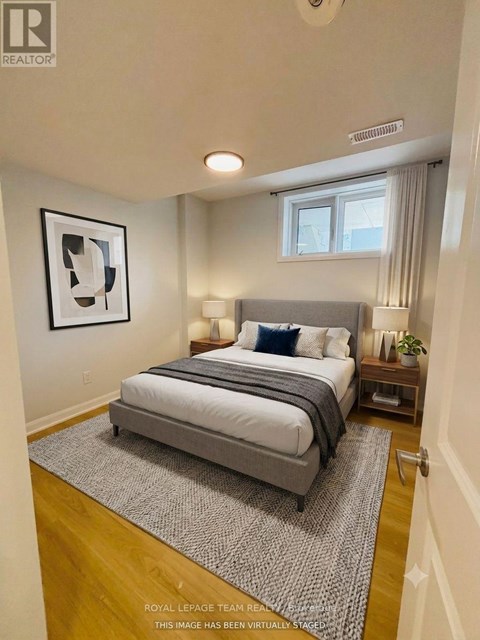 A bedroom with a large bed and a framed picture on the wall.