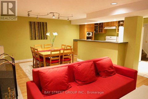 A living room with a red couch and a dining table.