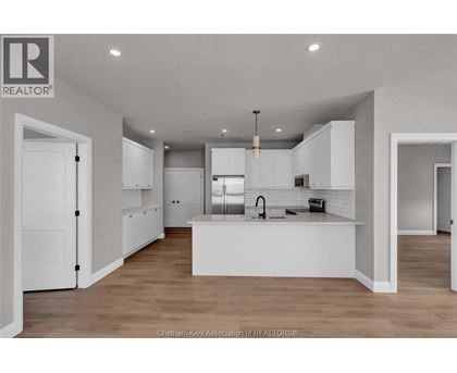 A modern kitchen with white cabinets and a central island.