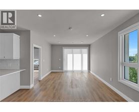 A spacious, empty room with a large window on the right side.