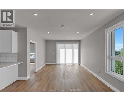 A spacious, empty room with a large window on the right side.